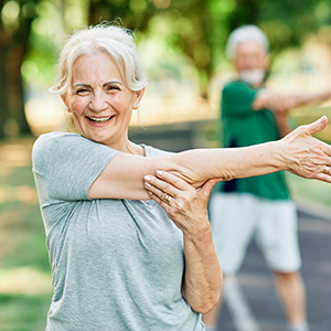 Older adult stretching during outdoor exercise